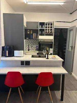 a kitchen with two red chairs at a counter at TLP Haven in Cape Town