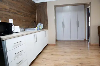 a kitchen with white cabinets and a wooden wall at 20 On Percy Unit 3 in Parkwood