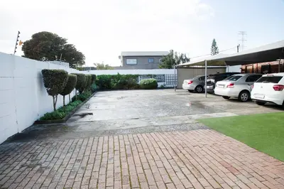 a parking lot with cars parked next to a building at 20 On Percy Unit 3 in Parkwood