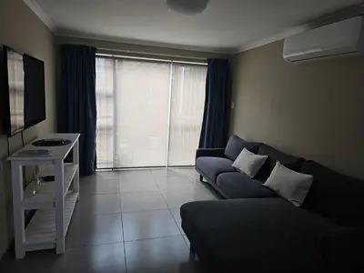 a living room with a couch and a large window at Evert's Home in Bellville
