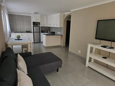 a living room with a couch and a flat screen tv at Evert's Home in Bellville