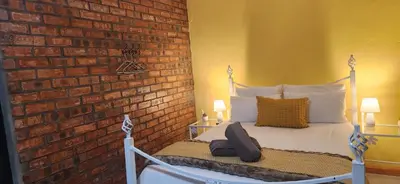 a bedroom with a bed with a brick wall at LyonsDen 2 in Worcester