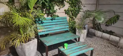 a green toy sitting on a blue bench next to plants at LyonsDen 2 in Worcester