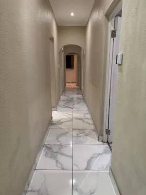 a hallway with white marble flooring in a building at Ewanges holiday home in Windsor Park
