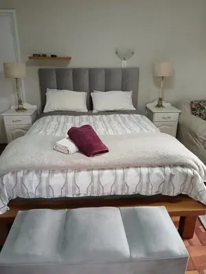 a bedroom with a large bed with a purple towel on it at Rusticana A in Cape Town