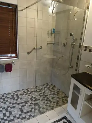 a shower with a glass door in a bathroom at Rusticana A in Cape Town