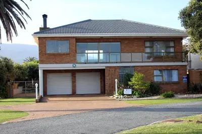 a brick house with two garage doors on a street at Grace Haven Self Catering in Hermanus