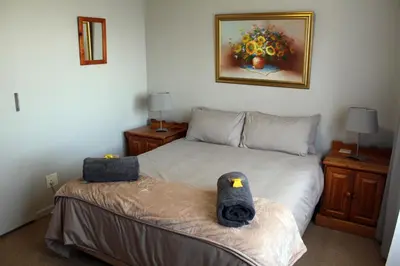 a bedroom with a bed with two stuffed animals on it at Grace Haven Self Catering in Hermanus
