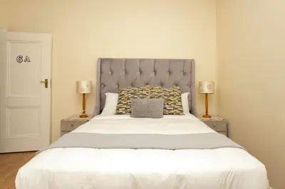 a bedroom with a large bed with two lamps at Serena Inn Apartment 6 Self Catering in Cape Town