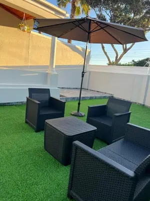 a group of chairs and a table with an umbrella at Serena Inn Apartment 6 Self Catering in Cape Town