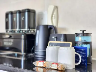 a counter with a coffee maker and coffee cups at Rivers Edge Apartment in Rondebosch with Balcony in Cape Town