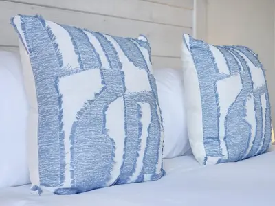 two blue and white pillows on a bed at Rivers Edge Apartment in Rondebosch with Balcony in Cape Town