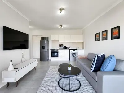 a living room with a couch and a table at Rivers Edge Apartment in Rondebosch with Balcony in Cape Town