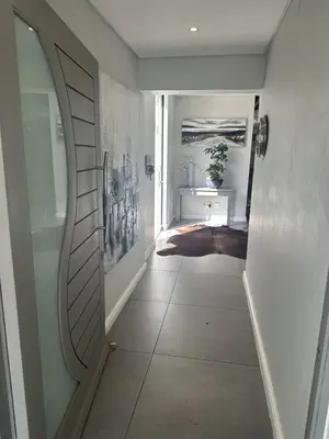 a hallway with a mirror and a hallway with a door at Sunset Links Golf Estate home, walk to Beach in Cape Town