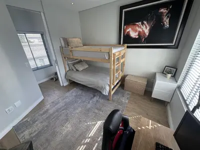 a small room with a bunk bed and a horse picture at Sunset Links Golf Estate home, walk to Beach in Cape Town