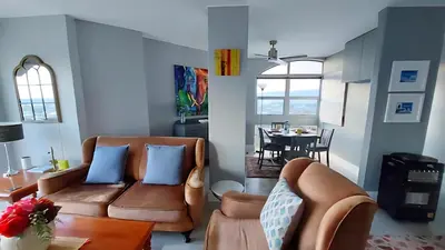 a living room with a couch and a table at Views Views and more Views Stunning 2 bed Apartment in Strand