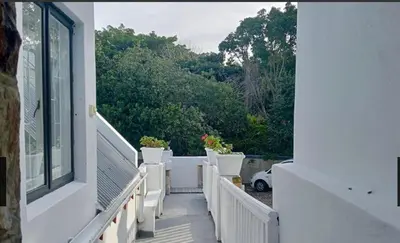 a balcony of a house with white stairs and plants at Studio at Providence in Hermanus