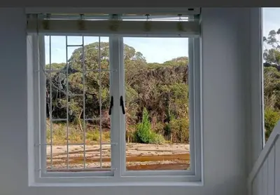 a window in a room with a view of a forest at Studio at Providence in Hermanus