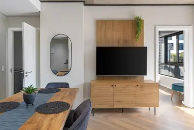 a living room with a television on a wooden dresser at Bridgewater One 309 in Cape Town