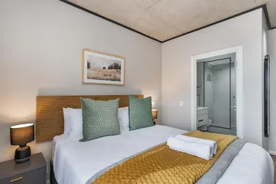 a bedroom with a large white bed with green pillows at Bridgewater One 309 in Cape Town