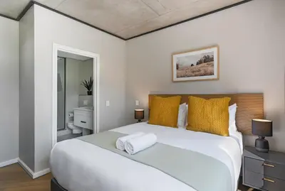 a bedroom with a large white bed with yellow pillows at Bridgewater One 309 in Cape Town