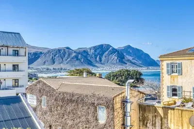 a view of the ocean and mountains from a building at Esplanade Hermanus Central Sea Views in Hermanus