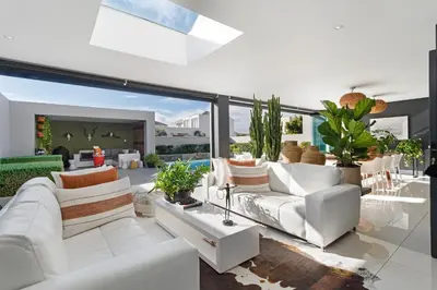 a living room with white furniture and large windows at Sunset Fairway Vista Villa in Cape Town