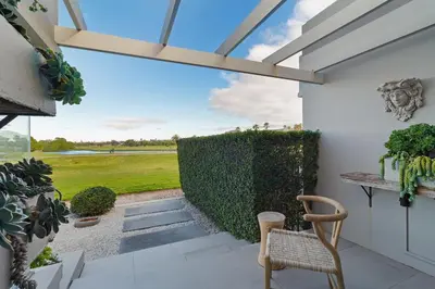 a patio with a chair and a hedge at Sunset Fairway Vista Villa in Cape Town