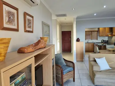a living room with a fireplace and a couch at Flat 9, Beachfront 2 Bedroom with Sea View for 4 in Gordonʼs Bay
