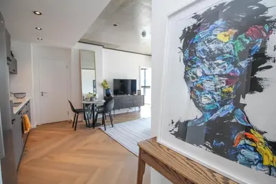 a painting of a woman on a wall in a living room at The Bridgewater Collection 409-Luxury 2 bed Modern Apartment at Century City in Cape Town