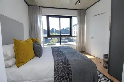 a bedroom with a bed with a large window at The Bridgewater Collection 409-Luxury 2 bed Modern Apartment at Century City in Cape Town