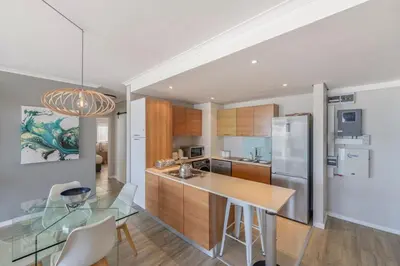 a kitchen with a glass table and a refrigerator at Horizon Bay 903 Fresh Beachfront Hideaway in Cape Town