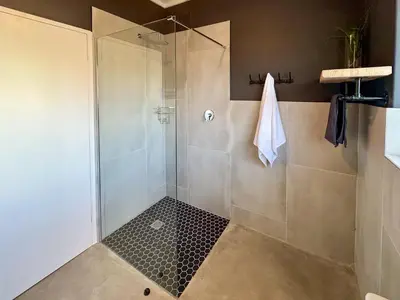 a bathroom with a shower with a glass door at Dublin - 2 Bedroom Apartment in Blomtuin