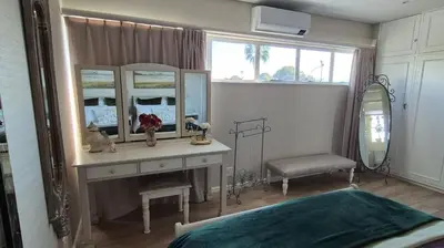 a bedroom with a dressing table and a mirror at The Pearl in the Winelands in Paarl