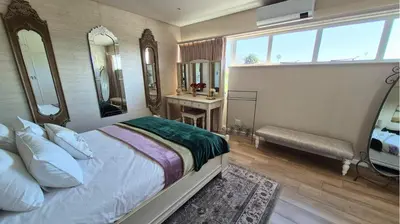 a bedroom with a bed and a sink and mirror at The Pearl in the Winelands in Paarl