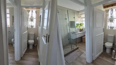 a bathroom with two toilets and a glass shower at The Pearl in the Winelands in Paarl