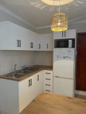 a kitchen with a white refrigerator and a sink at Worcester accommodation Putt and Stay in Worcester
