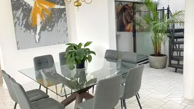 a dining room with a glass table and chairs at Ocean & Mountain View Apartment in Gordonʼs Bay