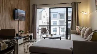 a living room with a couch and a large window at AlimamaSpaces The Fynbos Chelsea in Cape Town