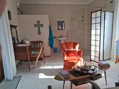 a living room with a chair and a table at Apple Pie Self-catering in Hermanus