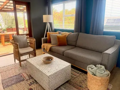 a living room with a couch and a table at Loft Escape in Onrus with Hot Tub- 2km from beach in Hermanus