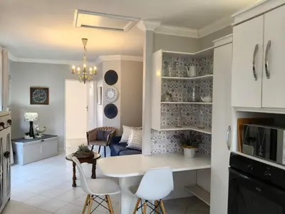 a kitchen and living room with a table and chairs at Strand and Sea Cottage in Strand
