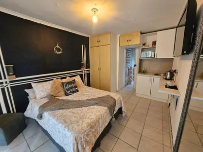 a small bedroom with a bed and a kitchen at 12 on lake Grassy Park in Parkwood