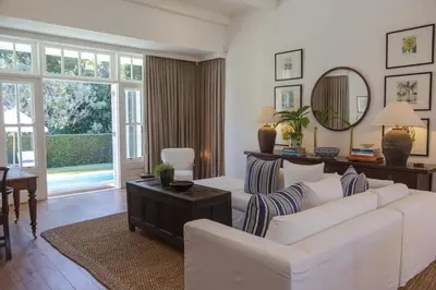 a living room with white furniture and a mirror at Lily Pond House at Le Lude in Franschhoek