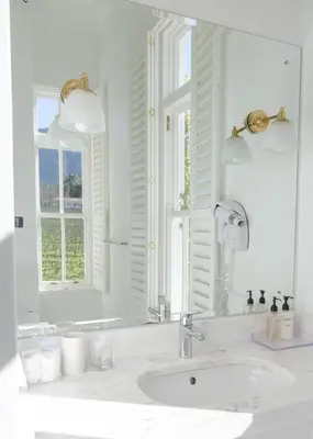 a white bathroom with a sink and a mirror at Lily Pond House at Le Lude in Franschhoek