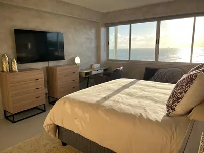 a bedroom with a large bed and a television at Casa Praia in Strand