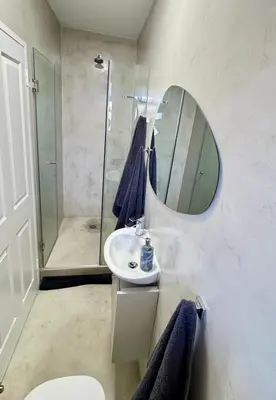 a bathroom with a shower and a sink and a mirror at Casa Praia in Strand