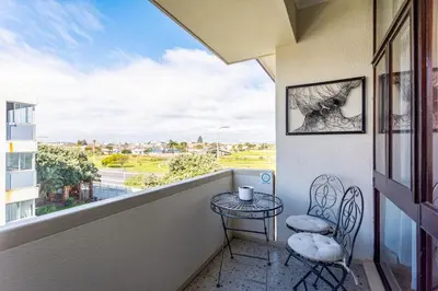 a balcony with a table and two chairs and a window at Burmeister Circle by CTHA in Cape Town