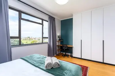 a bedroom with a bed and a large window at Burmeister Circle by CTHA in Cape Town