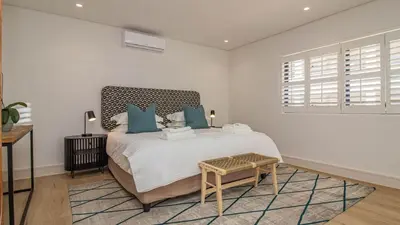 a bedroom with a large bed with blue pillows at Le Paradis 5 in Hermanus
